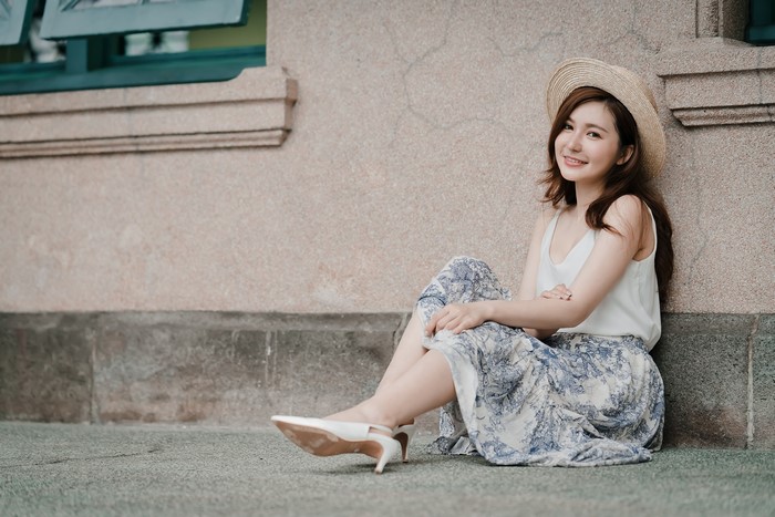 Asian woman with brown hair wearing a hat and skirt