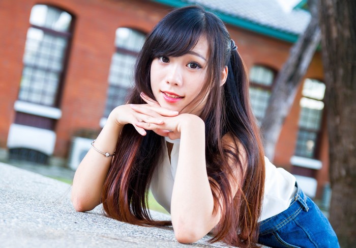 Asian woman with brown hair lying down