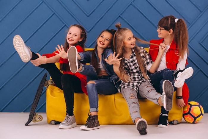 Four young girls sitting on a yellow couch