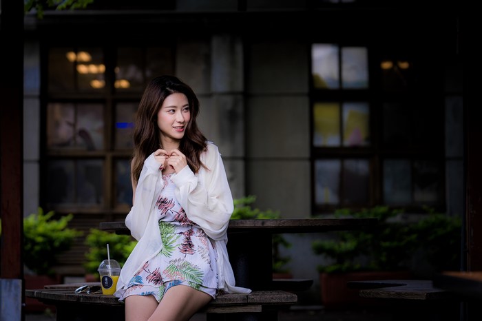 Asian woman with brown hair sitting outdoors