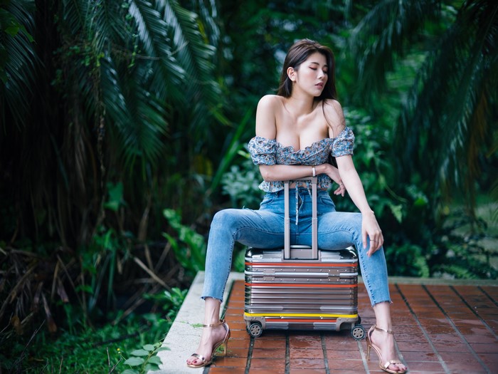 4K Asian Brunette Girl Sitting with Suitcase