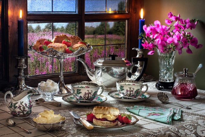 Still-life with tea set, scones, and strawberries by a window