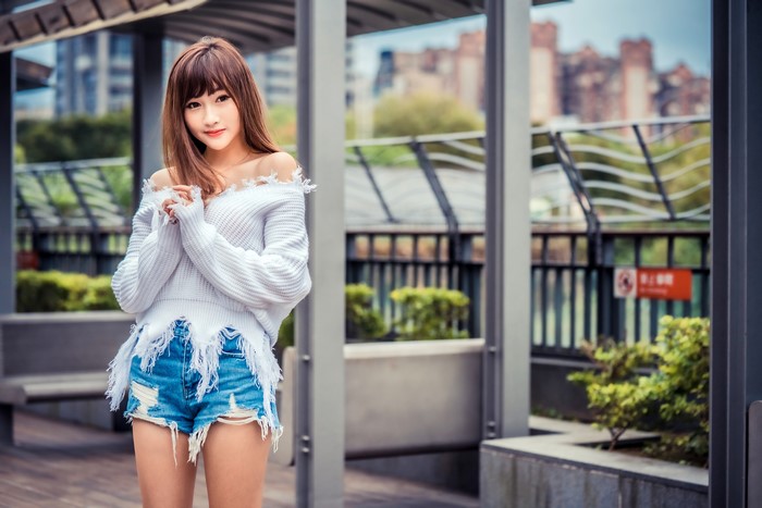 Asian woman in off-shoulder sweater and denim shorts