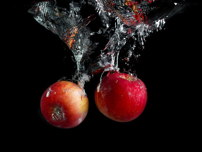 Two apples splashing into water