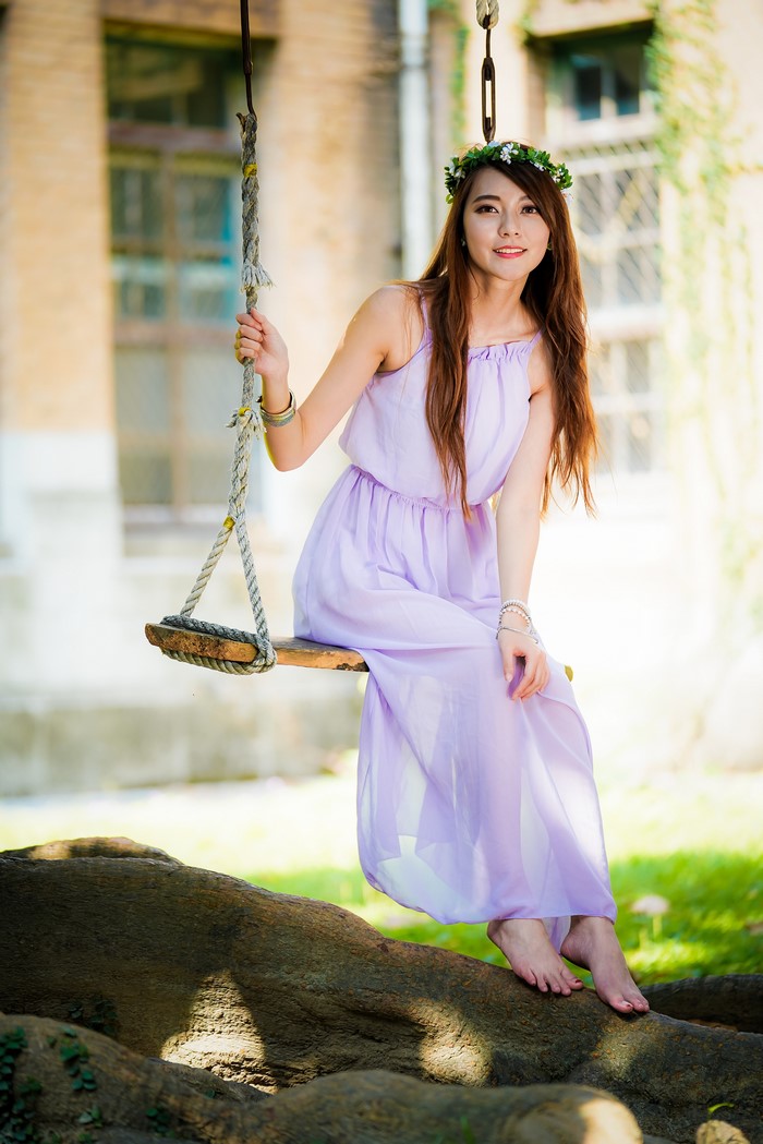 Asian woman wearing a flower wreath on a swing