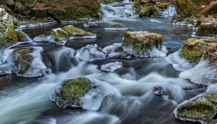 River with Ice and Mossy Stones in South-Eifel, Germany
