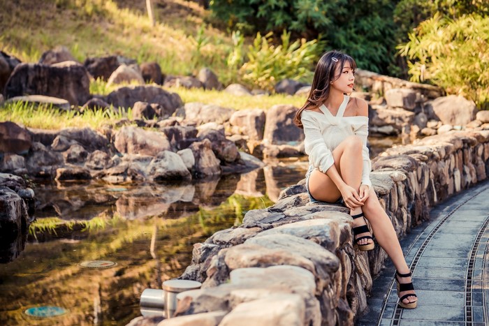 4K Asian Woman Sitting on Stone Wall