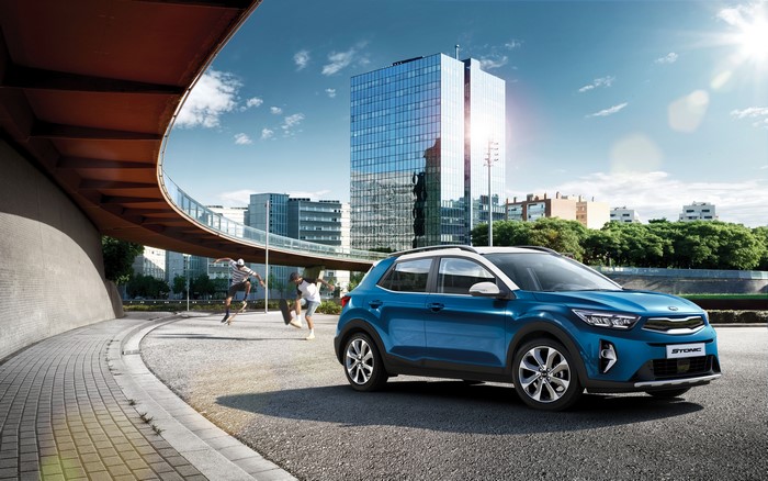 Blue Kia Stonic Crossover with Skaters and Modern Buildings