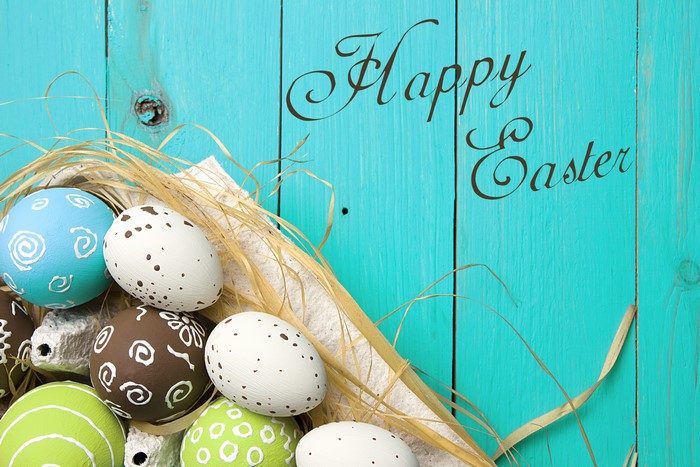 Happy Easter painted eggs on turquoise wood