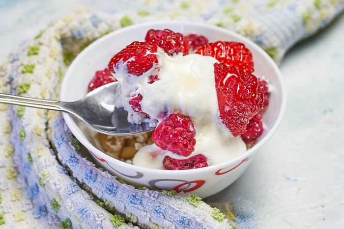 Raspberries with sour cream and a spoon
