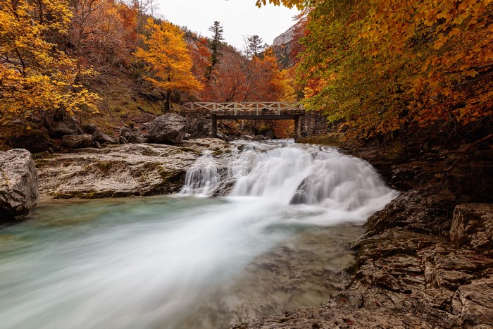 Autumn waterfall and bridge in Ordesa National Park, Spain