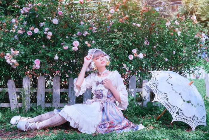 Woman in Lolita Dress with Umbrella by Rose Bush