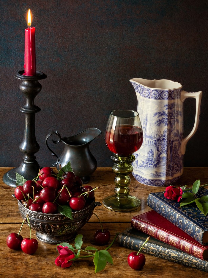 Still-life with cherries, candle, wine glass, and books