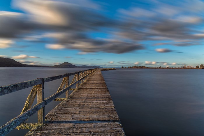 Wooden pier on Lake Taupo, New Zealand with streaky clouds