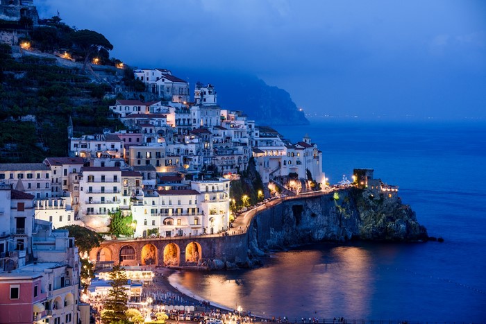 Amalfi Coast town at dusk with sea and mountains