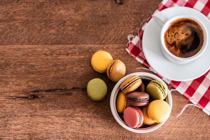 Coffee Cup and Macarons on Wooden Table