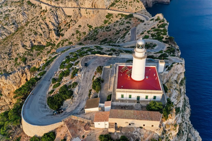 Lighthouse on a cliff with winding road in Mallorca, Spain