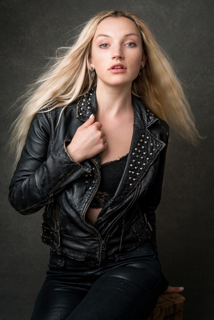 Olivia with blonde hair wearing a leather jacket