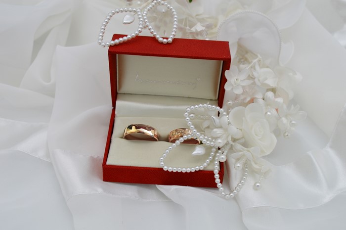 Wedding rings in a red box with pearls
