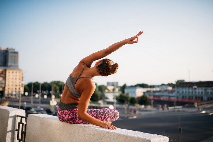 Woman doing yoga stretch exercise outdoors