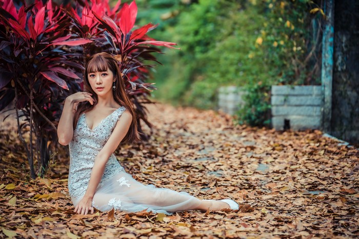 4K Asian Woman Sitting Among Foliage