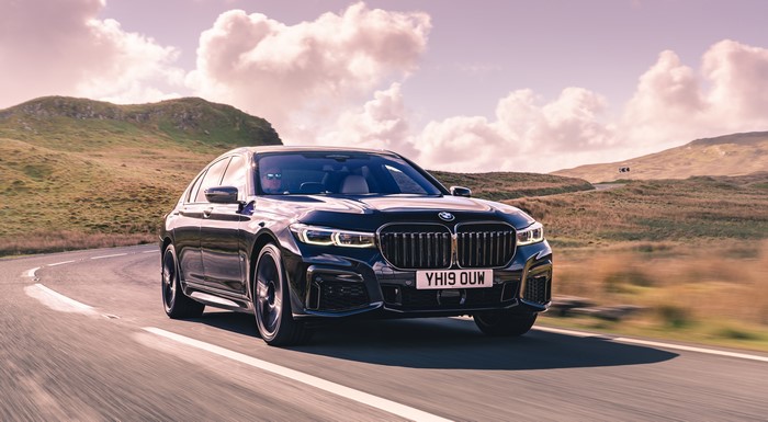 BMW Sedan driving on a scenic road