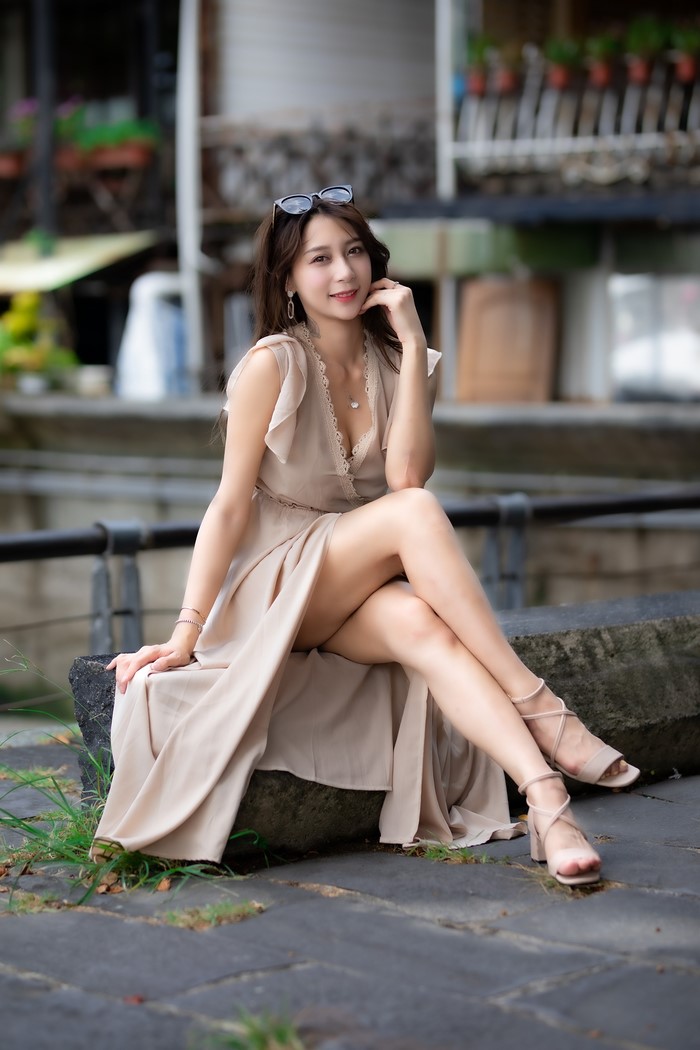 Asian Woman Sitting in Beige Dress
