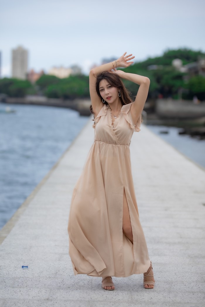 Asian woman in a dress posing by the water