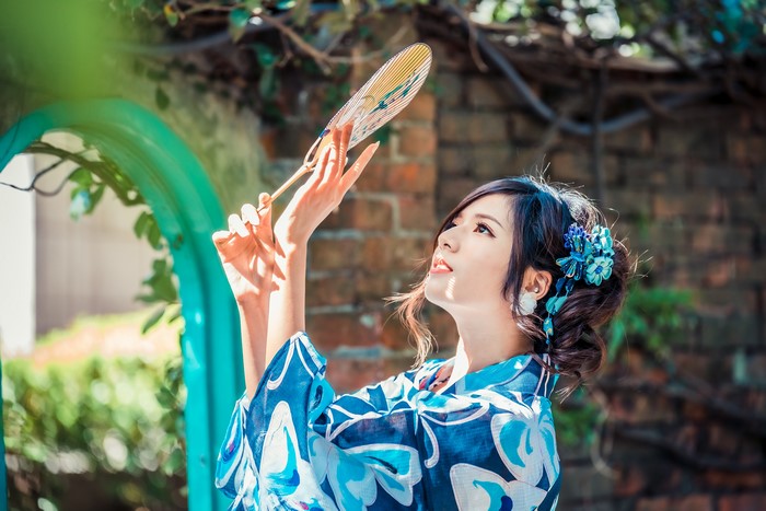 Asian woman in kimono holding a hand fan