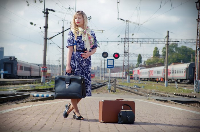 Blonde woman with luggage at a railway station