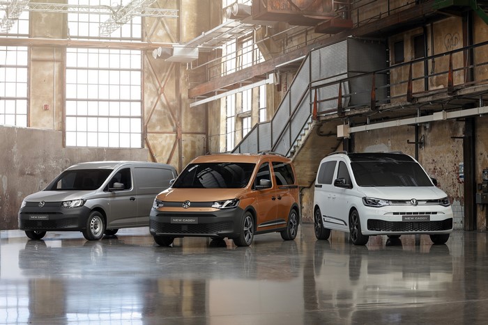 Three Volkswagen Caddy vans in a warehouse