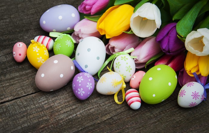 Easter eggs and tulips on a wooden background