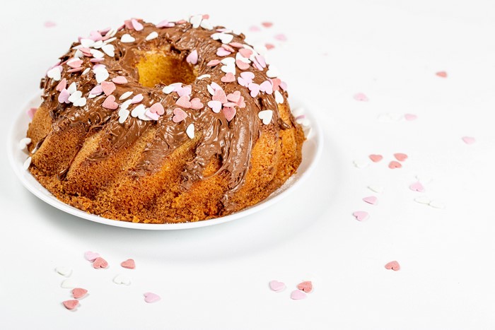 Bundt cake with chocolate frosting and heart sprinkles
