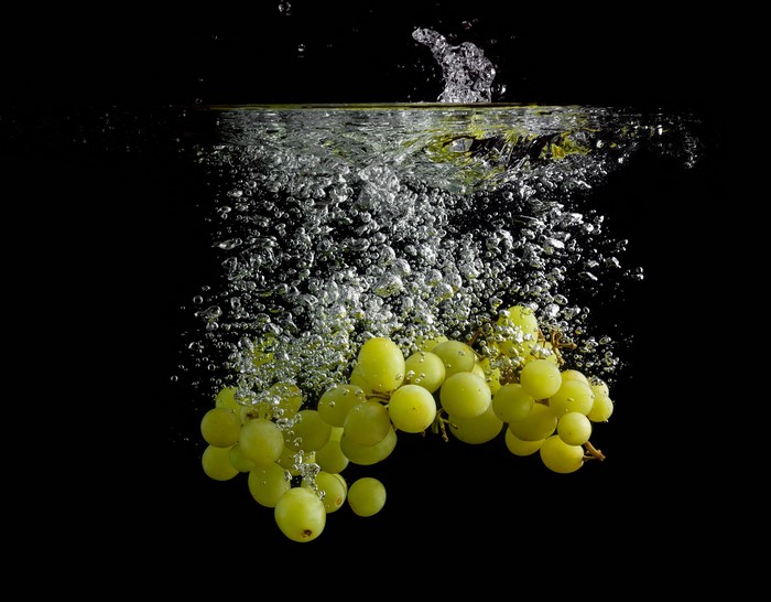 Green Grapes Splashing in Water with Bubbles