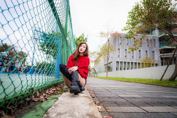 4K Asian Woman Sitting by Fence Wearing Boots
