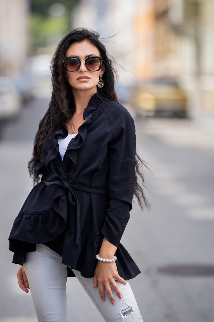 Brunette woman wearing sunglasses and a black jacket