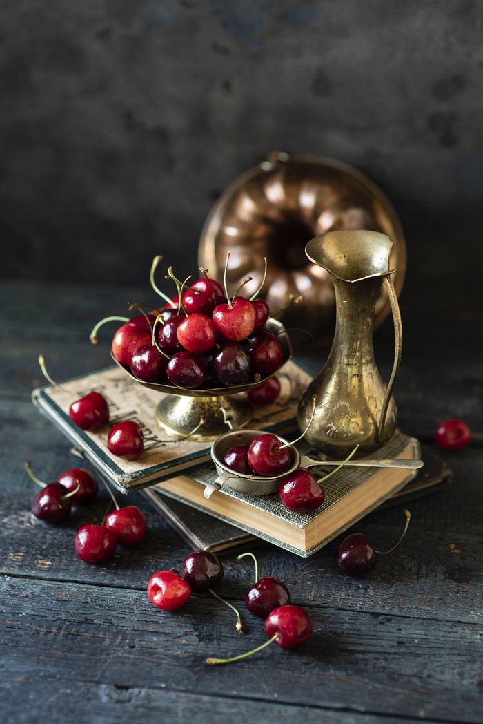 Still life with cherries, books, and a jug