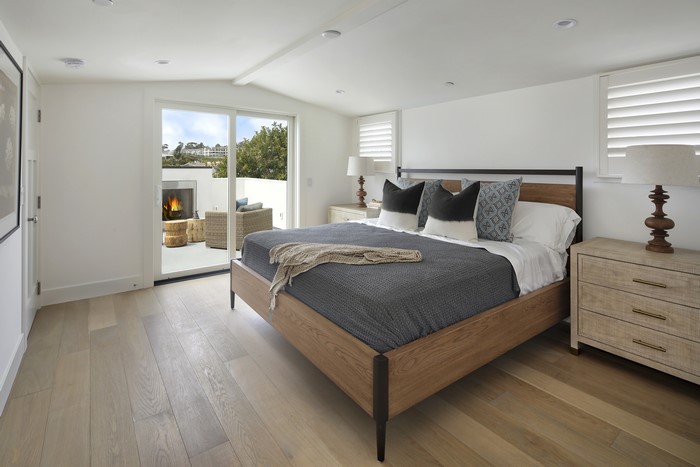 Bedroom with a bed, pillows, and a patio with a fireplace