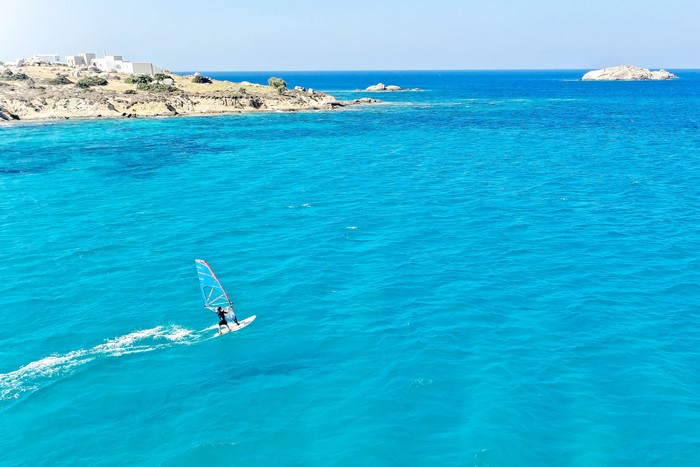 Windsurfer on turquoise water near Naxos City, Greece