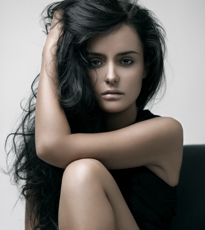 Brunette woman with dark hair posing