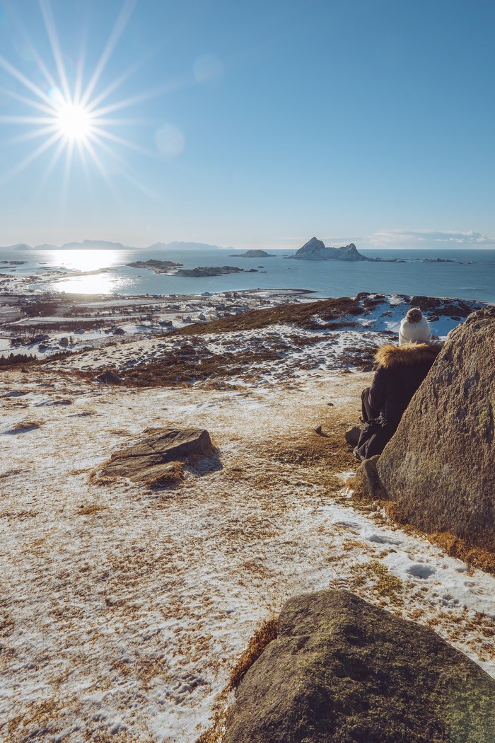 Person sitting on rocks overlooking Norwegian coast