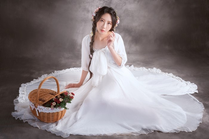 Asian woman in white dress with braid hair and wicker basket