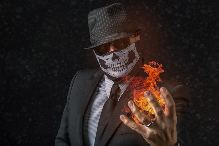 Man in Suit with Skull Mask and Fire