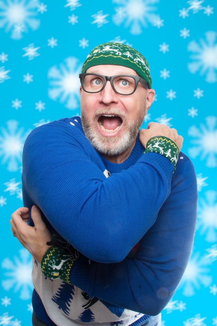 Man in Christmas sweater and hat with snowflakes