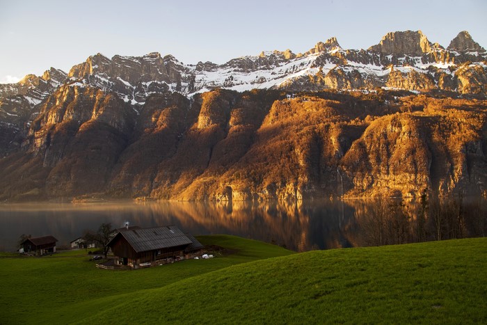 Snow-capped mountains over a lake with houses in Glarus, Switzerland