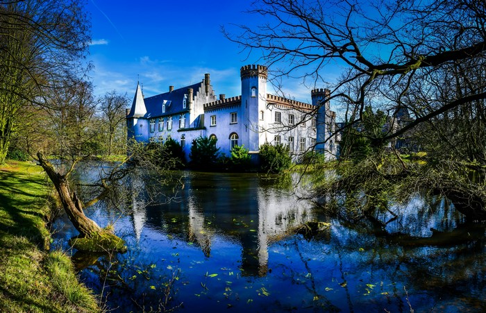 Stapelen Castle reflected in a pond with trees