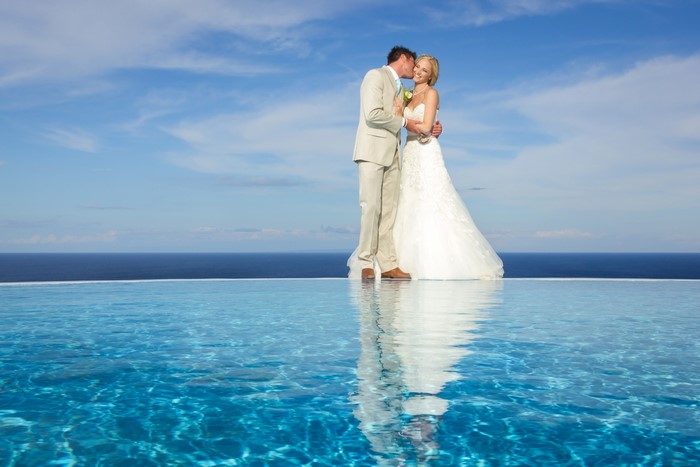 Bride and Groom kissing by infinity pool