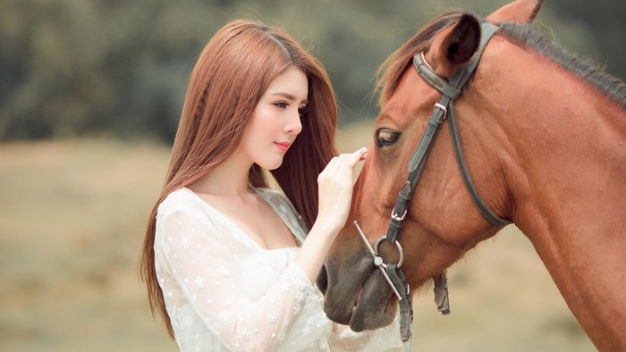 Asian woman with brown hair and a horse