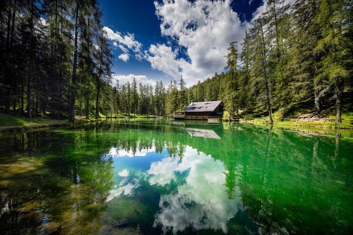 Wooden cabin on a lake in the Dolomites, Italy