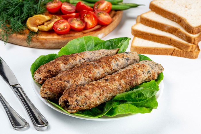 Kofta kebabs on lettuce with bread and vegetables